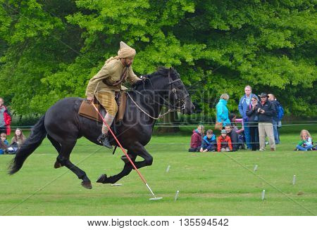 Silsoe, Bedfordshire, England - May 30, 2016: Demonstration of the sport of Tent Pegging at full gallop  by a member of the Punjab Lancers in World War One uniform
