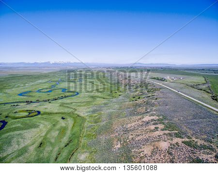 Illinois River meanders through Arapaho National Wildlife Refuge, North Park near Walden, Colorado, early summer aerial view