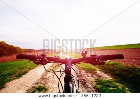 Mountain biking down hill descending fast on bicycle. View from bikers eyes.