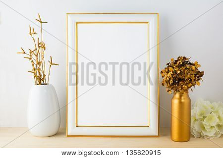 White frame mockup with white and golden vases. Portrait or poster white frame mockup. Empty white frame mockup for design presentation.