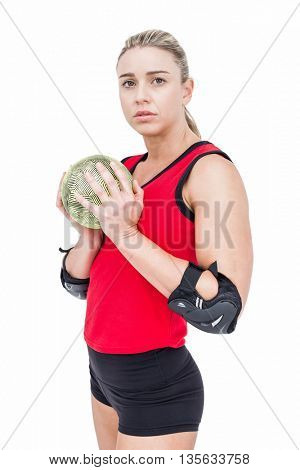 Female athlete with elbow pad holding handball on white background