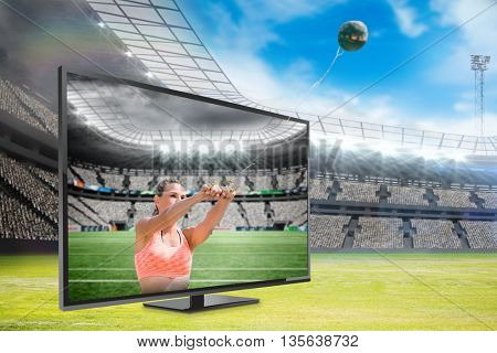 Portrait of sportswoman practising hammer throw against rugby stadium