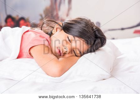 cute Indian Girl sleeping over white pillow, small asian girl sleeping on bed