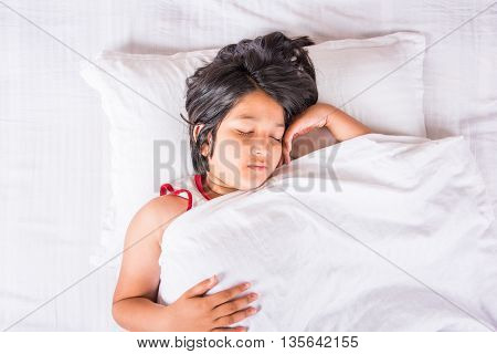 cute Indian Girl sleeping over white pillow, small asian girl sleeping on bed