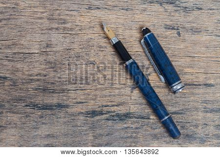 Fountain pen on old and grune wooden background