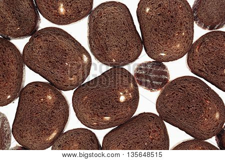 Slices of black rye bread on a white background. Food background. Pattern.