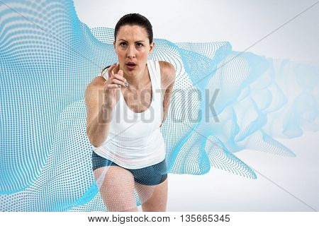 Energetic female athlete running against grey background