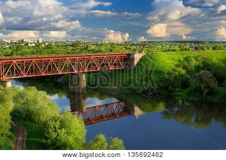 Railway bridge across small river in sunny summer day horizontal