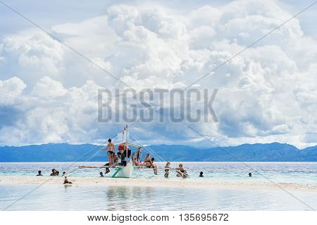 Moalboal. Cebu. Philippines. - 24 june 2016: Asian people and tourists getting fun and rest on the boat in tropical sea under scenic cloudy sky at sunny day