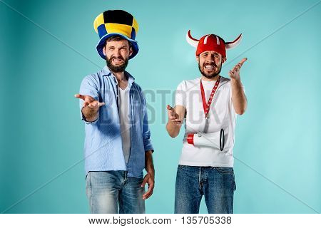 The two football fans with mouthpiece over blue background