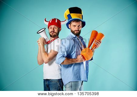 The two football fans with mouthpiece over blue background