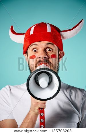 The football fan singing the national anthem over blue background