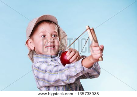 Young Boy Use Sling Shot Shoot Apple.