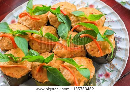 Top view Thai steamed curry fish in banana leaf cups decorated with basil leaf (Hor Mok Pla)