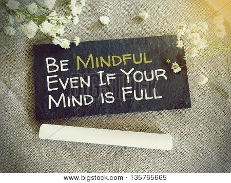 Blackboard for your text and flowers with words Be mindfull even if your mind is full