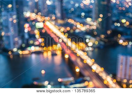 Blurred bokeh lights aerial view city bridge cross river night view, abstract background