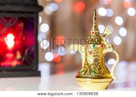 Gold Arabic Coffee pot in colorful illuminated background. Ramadan and Eid Mubarak concept background
