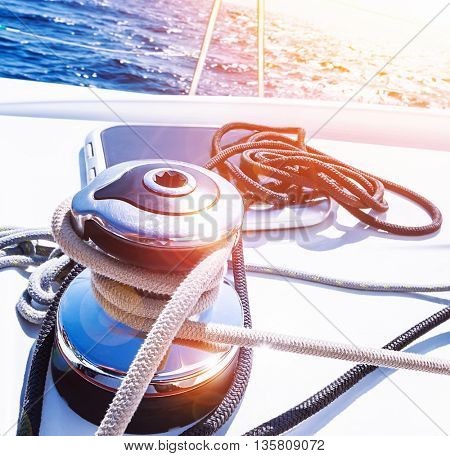 Crank handle of sailboat, detail of yacht, holder for rope, bright sunset in the sea, summer holidays, luxury water transport, yachting sport concept 