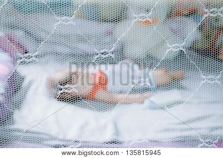 Child sleeping under mosquito net , provides mosquito nets to protect evacuees from dengue fever