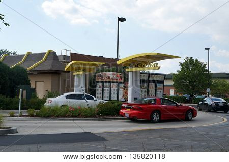 NAPERVILLE, ILLINOIS / UNITED STATES - JULY 23, 2015: Motorists use the drive-through service to purchase food at the McDonald's Restaurant in Naperville.
