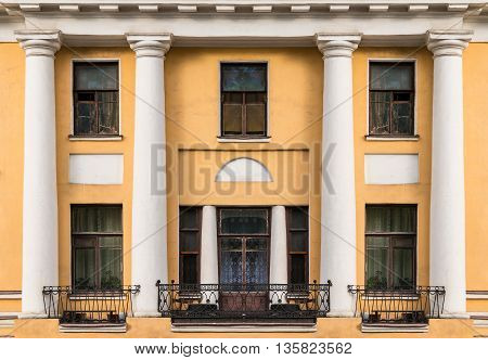 Several windows columns and balconies in a row on facade of urban apartment building front view St. Petersburg Russia