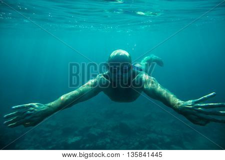 man swim underwater sea dive in clear water