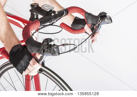 Cyclist Hands in Protective Gloves Put on Handlebars. Pressing Front and Rear Brakes Levers. Against White. Horizontal Image Orientation