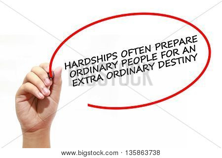 Man writing HARDSHIPS OFTEN PREPARE ORDINARY PEOPLE FOR AN EXTRA ORDINARY DESTINY with marker on transparent wipe board.