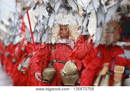 Pernik, Bulgaria - January 30, 2010: Unidentified man in traditional Kukeri costume are seen at the Festival of the Masquerade Games Surva in Pernik, Bulgaria.