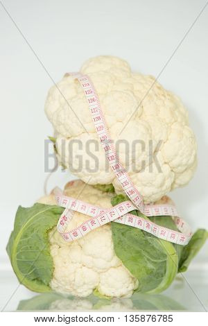 Cauliflower two(2) with measuring tape. Healthy eating. Healthy lifestyle. Diet. Source of vitamins. Vegetarian. Weight loss.