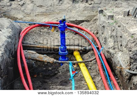 Connecting colorful underground cables and mains at a housing project in the Netherlands.