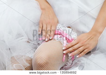 Wedding preparations. Hands of the bride and garter