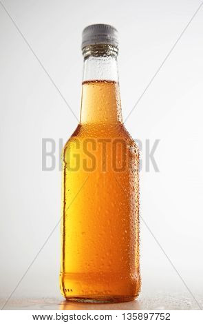 Transparent glass sealed bottle isolated on simple background in center and tasty drink inside mockup