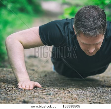 Handsome Man Doing Push-ups In The Forest.