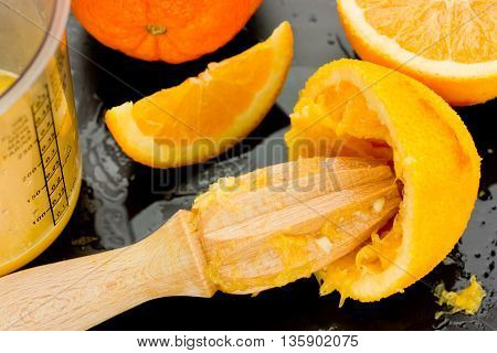 Squeezing oranges to make fresh and natural juice cooking and health concept selective focus