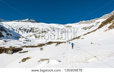 Skiers ascending a mountain slope. Ski touring in Malta valley, Austria.