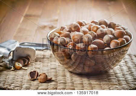 Hazelnuts in a bowl ready to use. Tool for chopping nuts woven cloth. Healthy food.