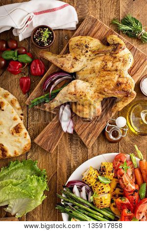 Grilled vegetables and chicken on wooden table overhead shot