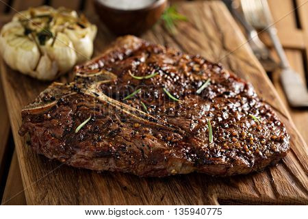 Tbone beef steak cooked on a grill with rosemary and garlic