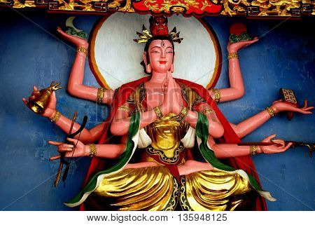 Dujiangyan China - May 18 2007: Buddha with multiple arms in the historic Jianfu Palace at Mount Qingchang