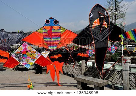 Dujiangyan China - April 8 2011: Colourful kites are displayed alongside the Min River quay
