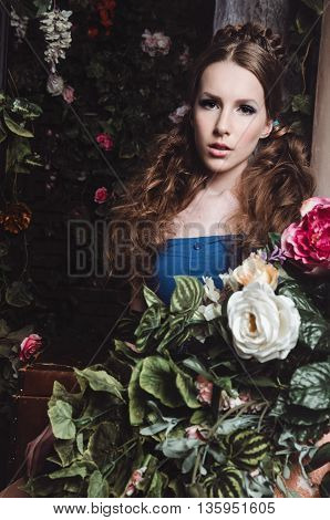 Spring fashion girl outdoors portrait in blooming dark garden. Beauty Romantic woman in flowers. Sensual Lady. Beautiful Woman Enjoying Nature. Romantic beauty in fantasy orchard.