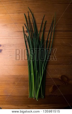Fresh green chives on wooden board