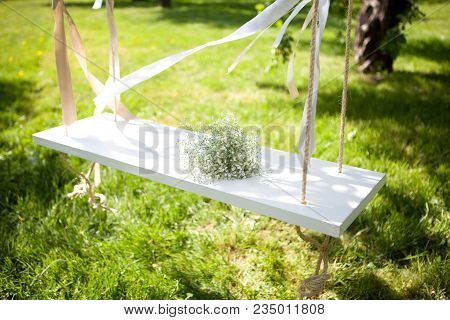 White Swing With Bunch Of White  Flowers In Sunny Day In Kolomenskoye Park In Moscow