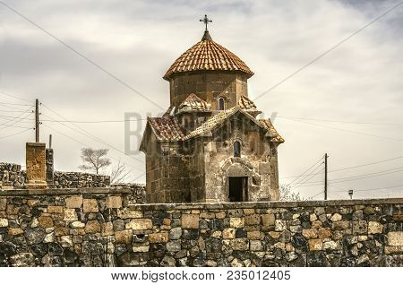 Small Cross-shaped Church Of Karmravor In Honor Of The Blessed Virgin Mary Behind A Stone Fence In T