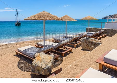Sun Loungers With Umbrellas On Beautiful Sandy Paleochori Beach On Milos Island. Cyclades, Greece.