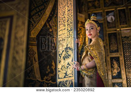 Beautiful Asia Woman In Gorgeous Antique Thai Dress Stand Near Ancient Gold Threads Old Thai Pattern