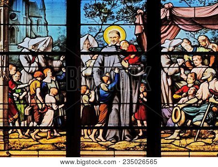 PARIS, FRANCE - JANUARY 04: Saint Vincent de Paul gathering with the Daughters of Charity abandoned children, stained glass window in Saint Severin church in Paris, France on January 04, 2018.