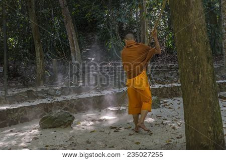 A Monk Is Worshiping And Meditating In Front Of The Golden Buddha In Garden Of Wat Suan Mok Phalaram