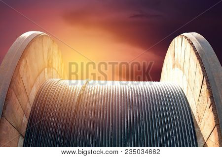 Black Wire Electric Cable On Wooden Under The Sky Background.